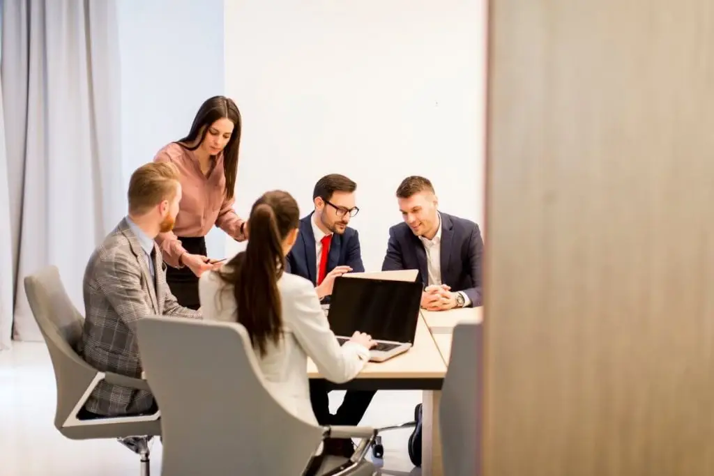 Equipa em reunião de consultoria a analisar dados e estratégias em ambiente empresarial